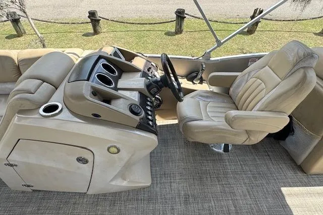 Slide: The Image of 2016 Bennington 2575 RCW boat interior with beige captain's chair and control panel. - 9