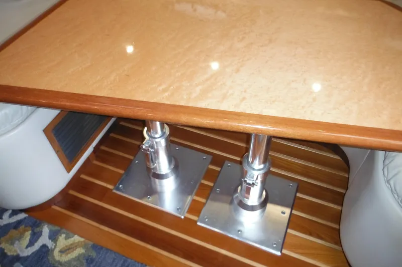 Slide: The Image of Interior of 2001 Tiara Yachts 3500 Open, featuring a polished wooden table and metal supports. - 100