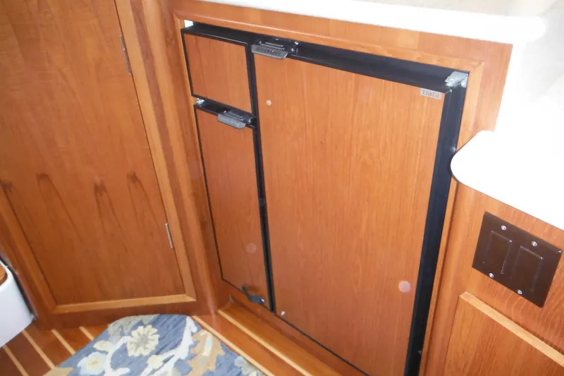 Slide: The Image of 2001 Tiara Yachts 3500 Open interior with wooden cabinetry and compact refrigerator. - 103