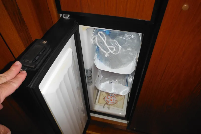 Slide: The Image of Small refrigerator inside 2001 Tiara Yachts 3500 Open, containing ice and items. - 105