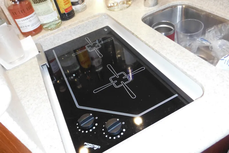 Slide: The Image of Stovetop in 2001 Tiara Yachts 3500 Open galley, with nearby sink and bottles. - 116