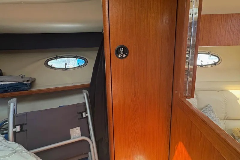 Slide: The Image of Interior of 2001 Tiara Yachts 3500 Open, featuring wooden paneling and porthole windows. - 136