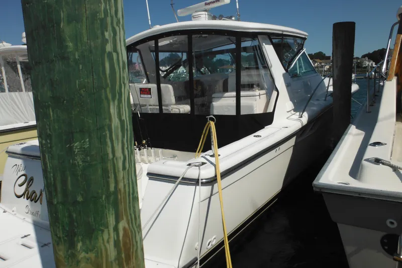 Slide: The Image of 2001 Tiara Yachts 3500 Open docked, featuring sleek design and enclosed cockpit. - 6