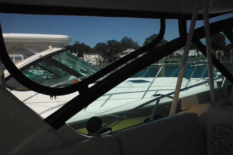 Slide: The Image of 2001 Tiara Yachts 3500 Open docked, viewed through cabin window, with marina background. - 62