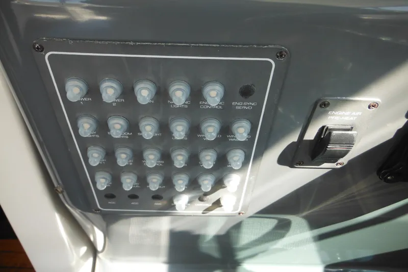 Slide: The Image of Control panel of a 2001 Tiara Yachts 3500 Open, featuring various switches and controls. - 77