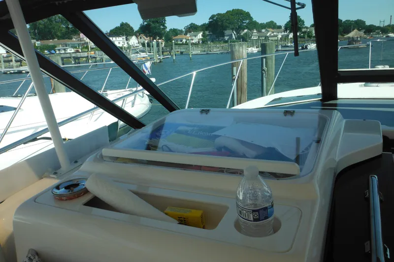 Slide: The Image of 2001 Tiara Yachts 3500 Open interior with marina view, featuring storage and bottled water. - 83