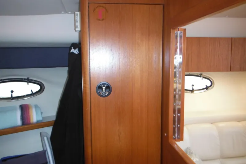 Slide: The Image of Interior of 2001 Tiara Yachts 3500 Open, featuring wooden cabinetry and porthole windows. - 89