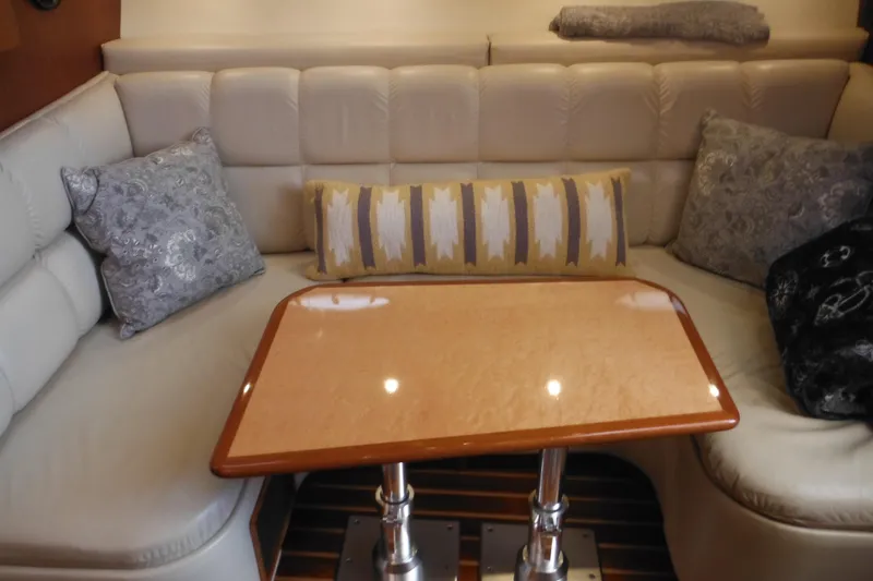 Slide: The Image of Interior of 2001 Tiara Yachts 3500 Open with cushioned seating and wooden table. - 94
