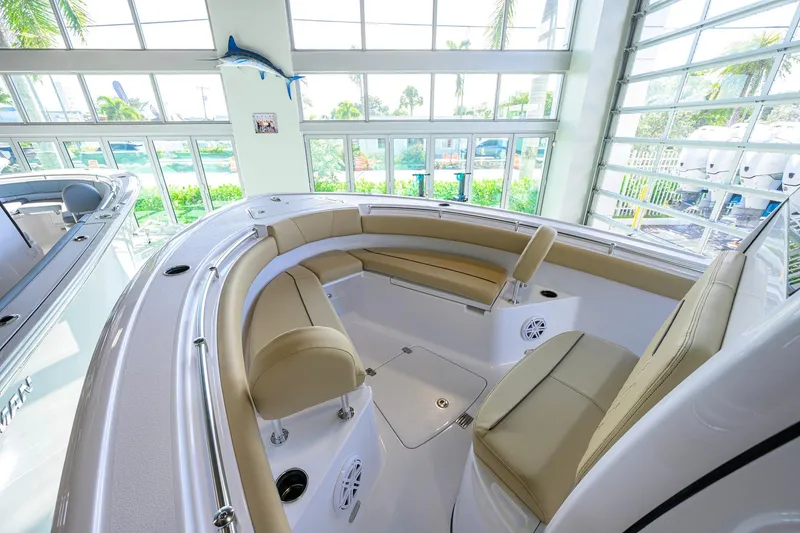 Slide: The Image of 2026 Sportsman Open 212 Center Console boat interior with beige seating in a showroom. - 14