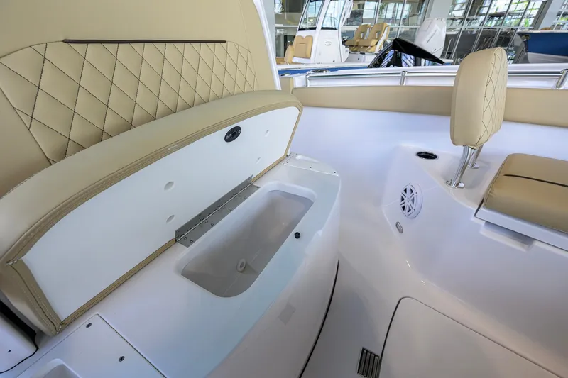 Slide: The Image of 2026 Sportsman Open 212 Center Console interior with beige seating and storage compartment. - 18