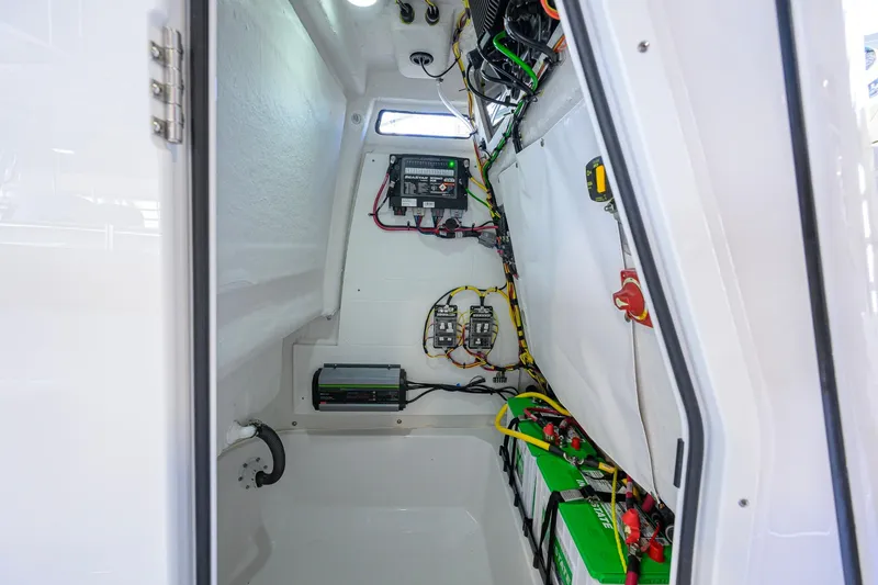 Slide: The Image of Electrical compartment of 2026 Sportsman Open 212 Center Console boat, showcasing wiring and batteries. - 36