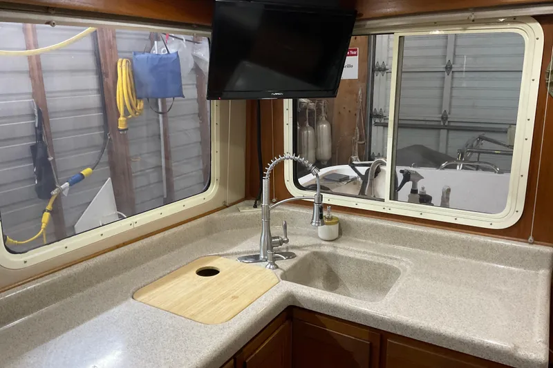Slide: The Image of American Tug 2002 Hull #24 kitchen with sink, countertop, and window view. - 15