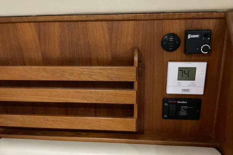 Slide: The Image of Wooden control panel on 2002 American Tug Hull #24 with thermostat and switches. - 17