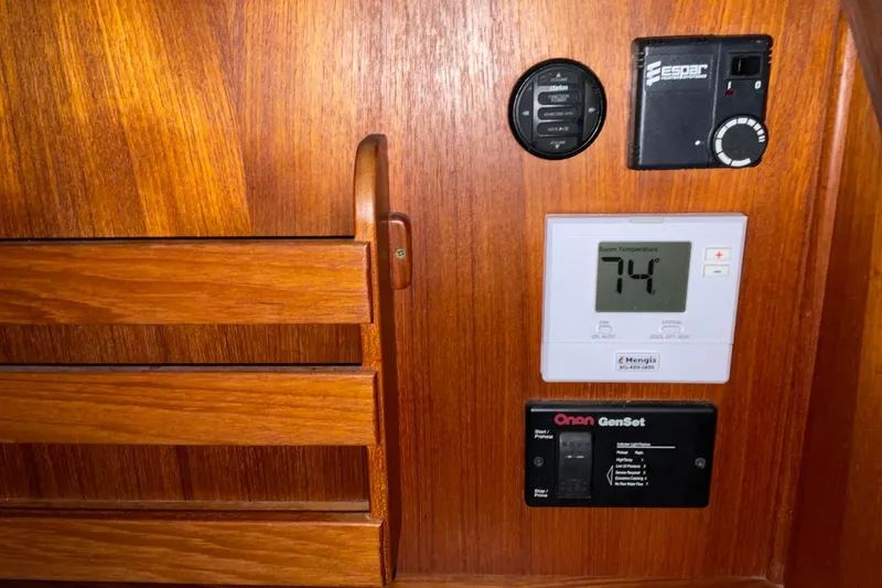 Slide: The Image of Control panel on 2002 American Tug Hull #24 with temperature display and generator controls. - 18