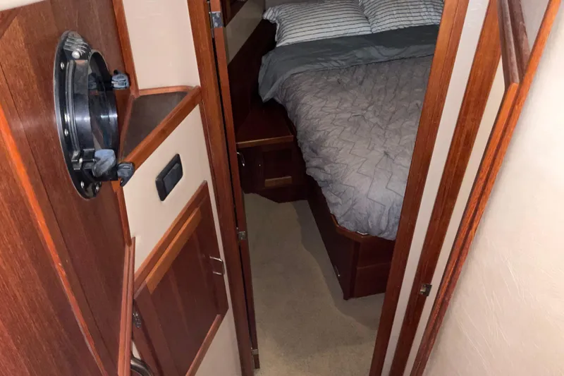 Slide: The Image of Cozy cabin interior of 2002 American Tug Hull #24 with bed and wooden accents. - 25