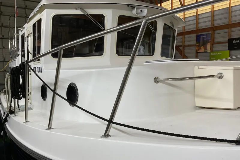 Slide: The Image of 2002 American Tug Hull #24 in a storage facility, showcasing its sleek design and sturdy railings. - 3