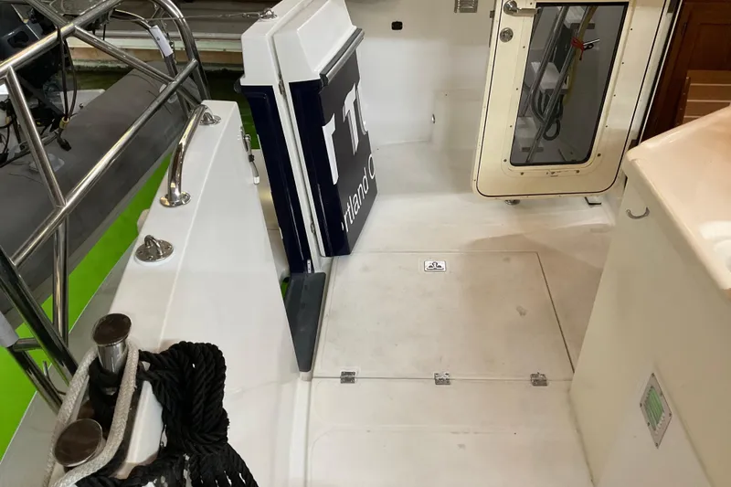 Slide: The Image of 2002 American Tug Hull #24 deck with railing, ropes, and cabin door. - 30