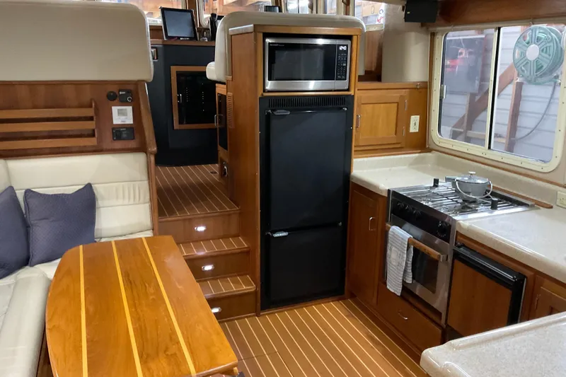 Slide: The Image of Cozy 2002 American Tug interior with kitchen, dining area, and wooden finishes. - 6
