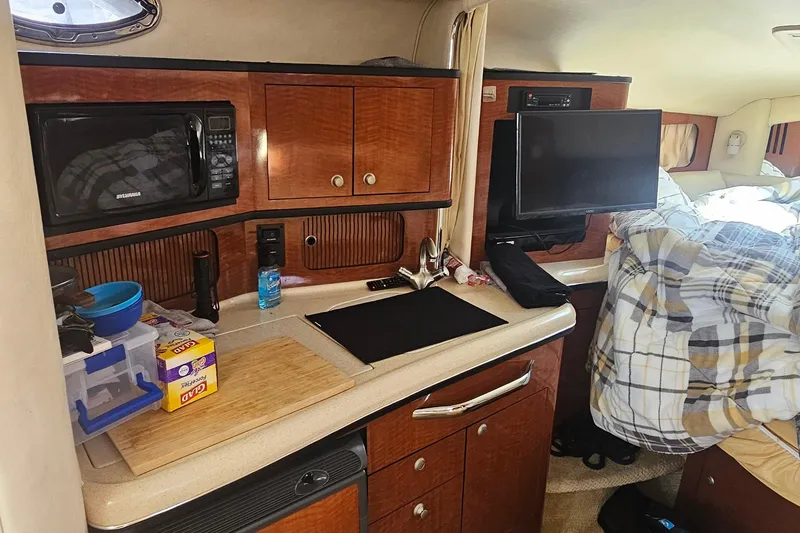 Slide: The Image of 2005 Sea Ray 300 Sundancer cabin interior with kitchenette and bed. - 12