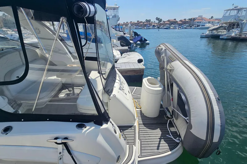 Slide: The Image of 2005 Sea Ray 300 Sundancer docked with inflatable boat, marina view. - 14