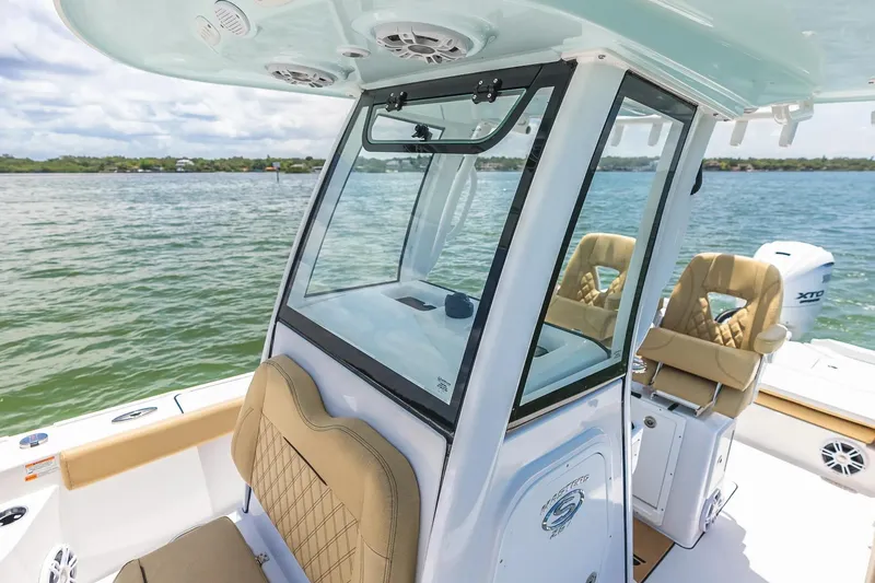 Slide: The Image of 2026 Sportsman Masters 267 Bay Boat interior with tan seating and console on water. - 10
