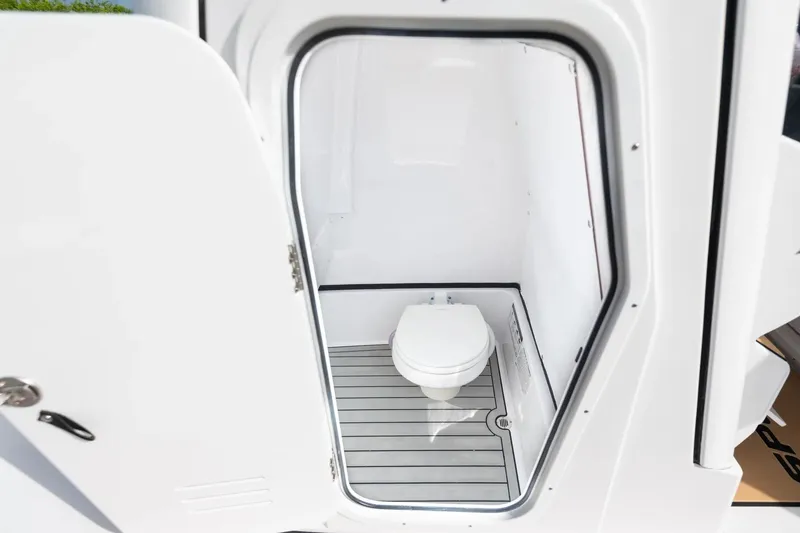Slide: The Image of 2026 Sportsman Masters 267 Bay Boat interior with compact marine toilet. - 12