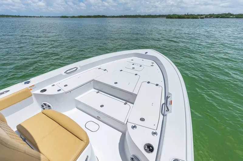 Slide: The Image of 2026 Sportsman Masters 267 Bay Boat on calm water, showcasing spacious deck and seating. - 2