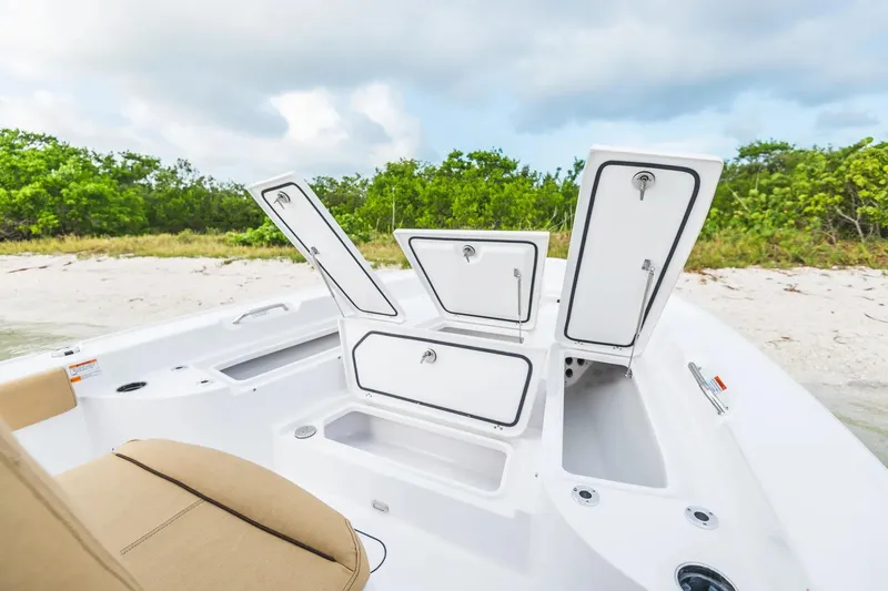 Slide: The Image of 2026 Sportsman Masters 267 Bay Boat with open storage compartments on a sandy beach. - 5