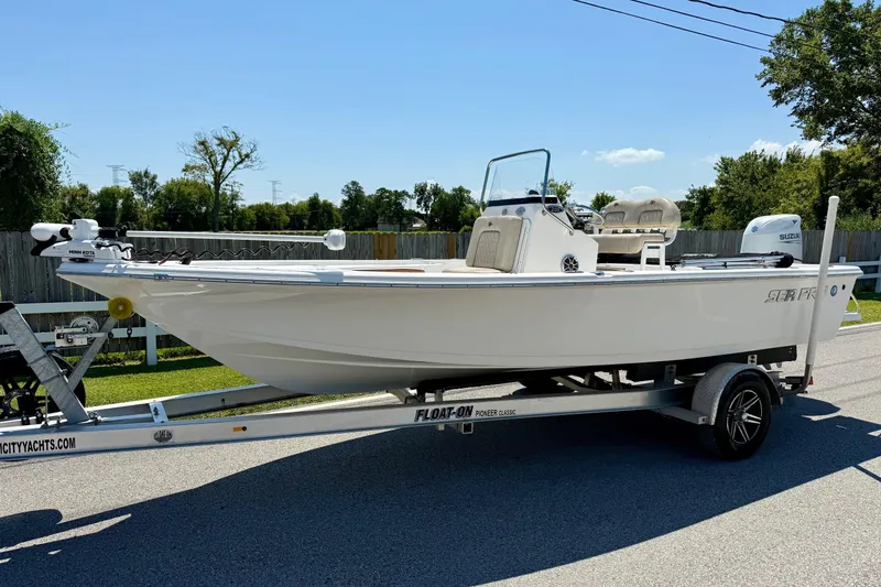 The Image of 2021 Sea Pro 208 Bay boat on trailer, parked outdoors on a sunny day. - 1