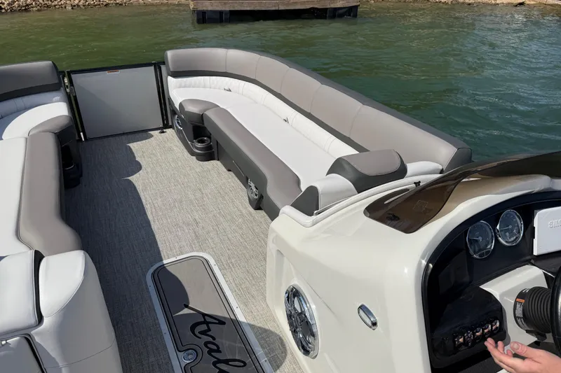 Slide: The Image of 2023 Avalon Catalina Versatile Rear Bench boat interior with plush seating and control panel. - 11