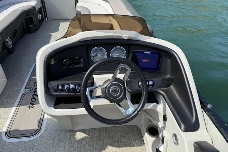 Slide: The Image of Steering console of 2023 Avalon Catalina Versatile Rear Bench boat on water. - 18
