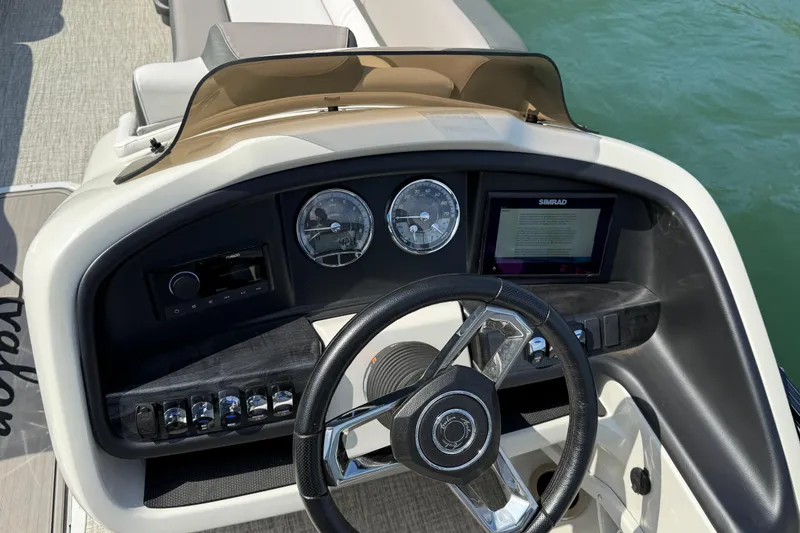 Slide: The Image of 2023 Avalon Catalina boat dashboard with steering wheel, gauges, and Simrad display. - 21