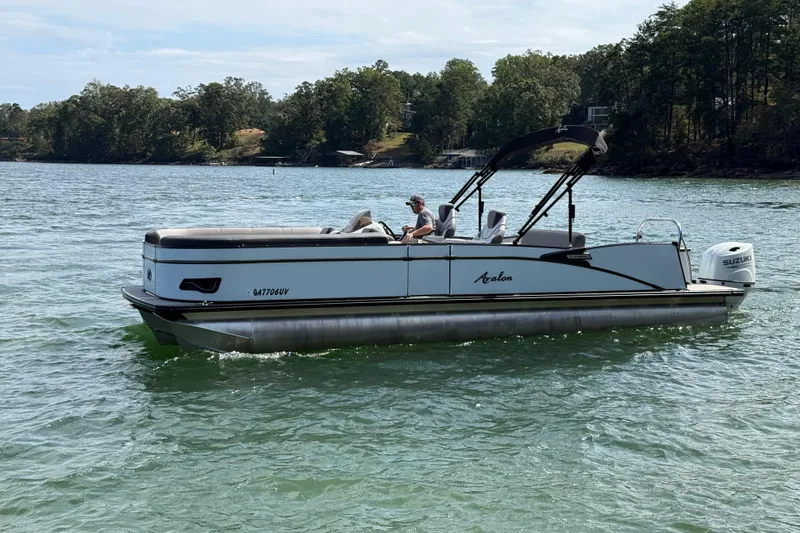 Slide: The Image of 2023 Avalon Catalina Versatile Rear Bench boat on a scenic lake. - 3