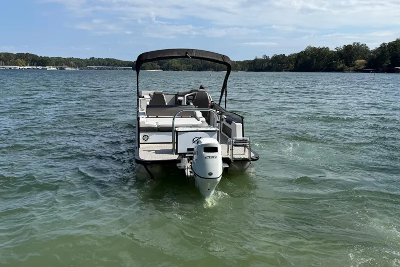 Slide: The Image of 2023 Avalon Catalina Versatile Rear Bench boat on a scenic lake. - 6