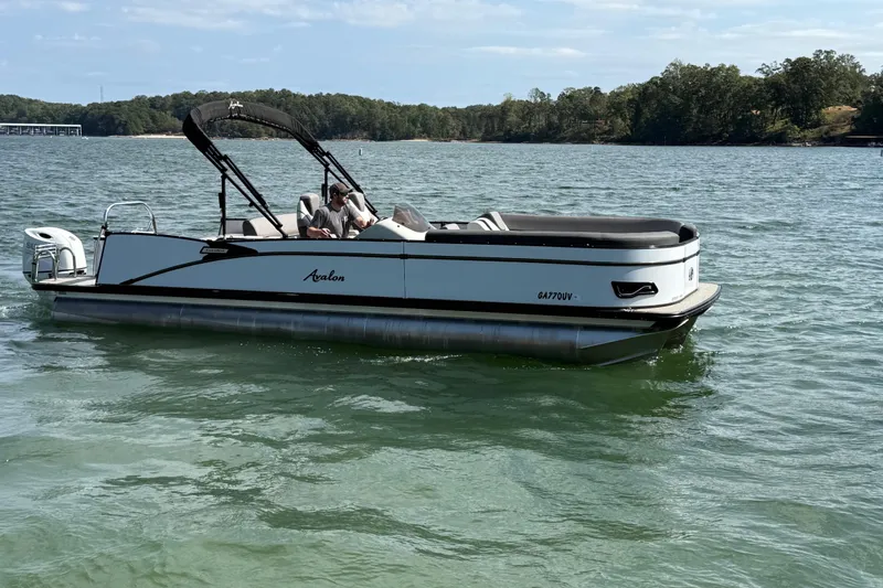 Slide: The Image of 2023 Avalon Catalina Versatile Rear Bench pontoon boat on a scenic lake. - 8