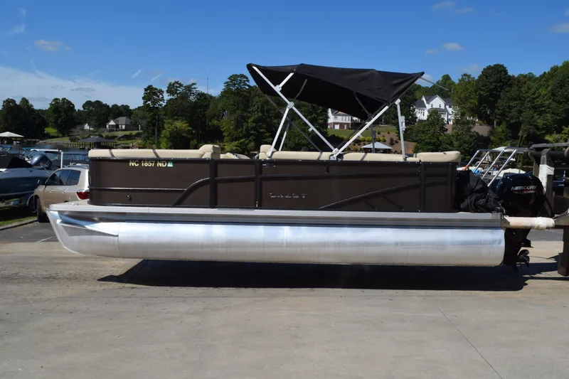 The Image of 2024 Crest Classic LX 220 L pontoon boat with canopy, parked on a sunny day. - 1