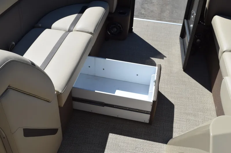 Slide: The Image of 2024 Crest Classic LX 220 L boat interior with open storage compartment under seat. - 11