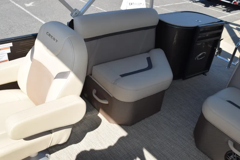 Slide: The Image of 2024 Crest Classic LX 220 L boat interior with beige seating and storage compartments. - 15