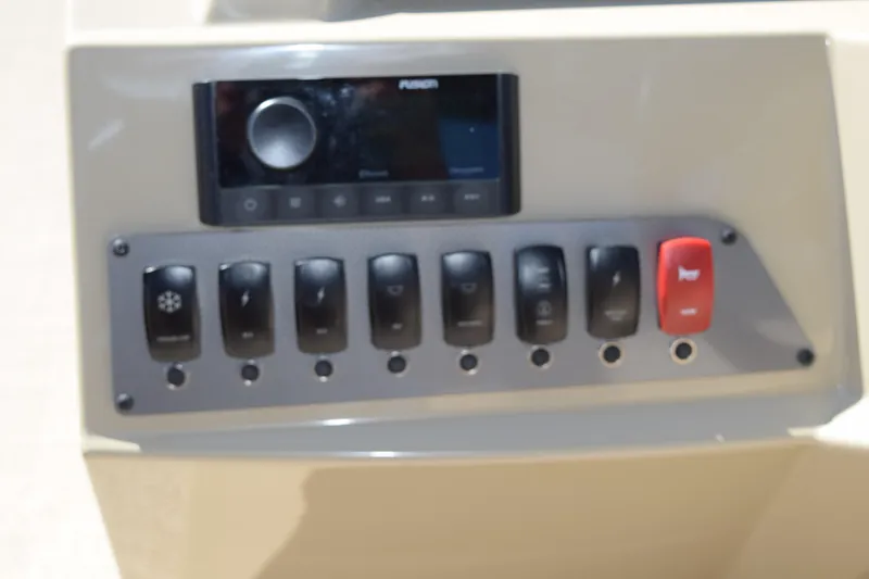 Slide: The Image of Control panel of 2024 Crest Classic LX 220 L boat with switches and audio system. - 20