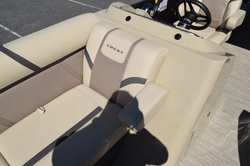 Slide: The Image of 2024 Crest Classic LX 220 L boat interior with beige seating and steering wheel. - 23