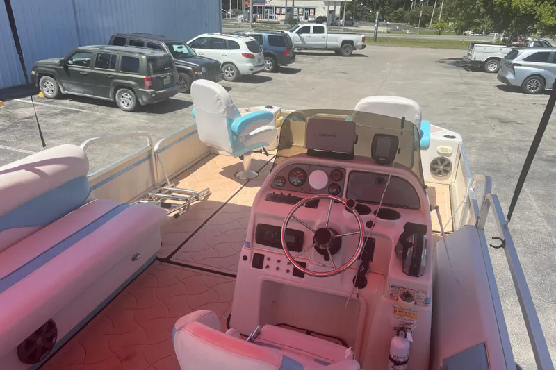 Slide: The Image of 2005 G3 LX20 boat interior with steering wheel, seats, and parked cars in background. - 13