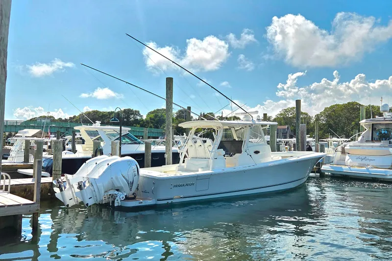 Slide: The Image of 2022 Regulator 37 boat docked in a sunny marina with clear skies. - 23