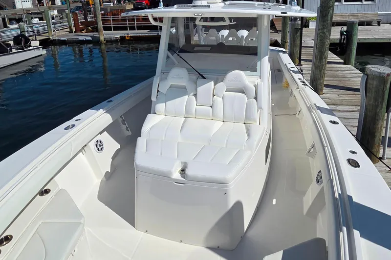 Slide: The Image of 2022 Regulator 37 boat with white seating, docked at a marina. - 9