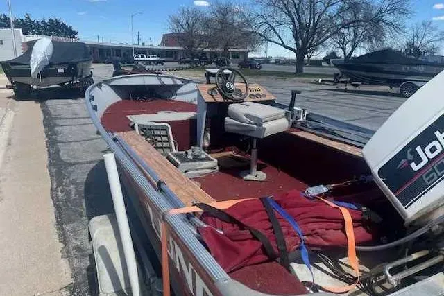 Slide: The Image of 1989 Lund 16 Rebel SS boat with Johnson outboard motor, parked on a trailer. - 3