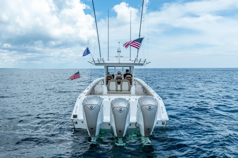 Slide: The Image of 2021 Everglades 395 Center Console boat on open sea with American flags. - 13
