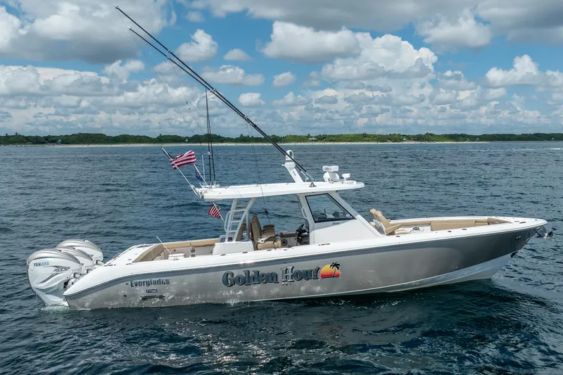 Slide: The Image of 2021 Everglades 395 Center Console boat on open water, with fishing rods and American flag. - 14