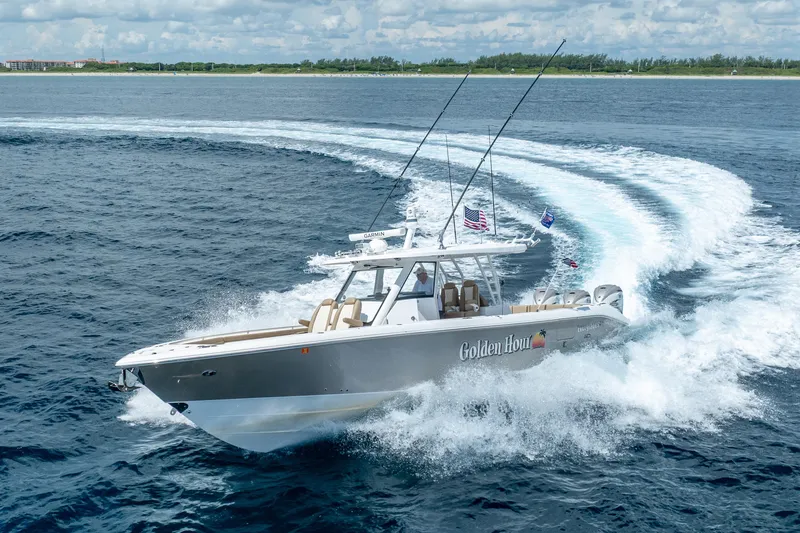Slide: The Image of 2021 Everglades 395 Center Console boat cruising on open water, creating a dynamic wake. - 16