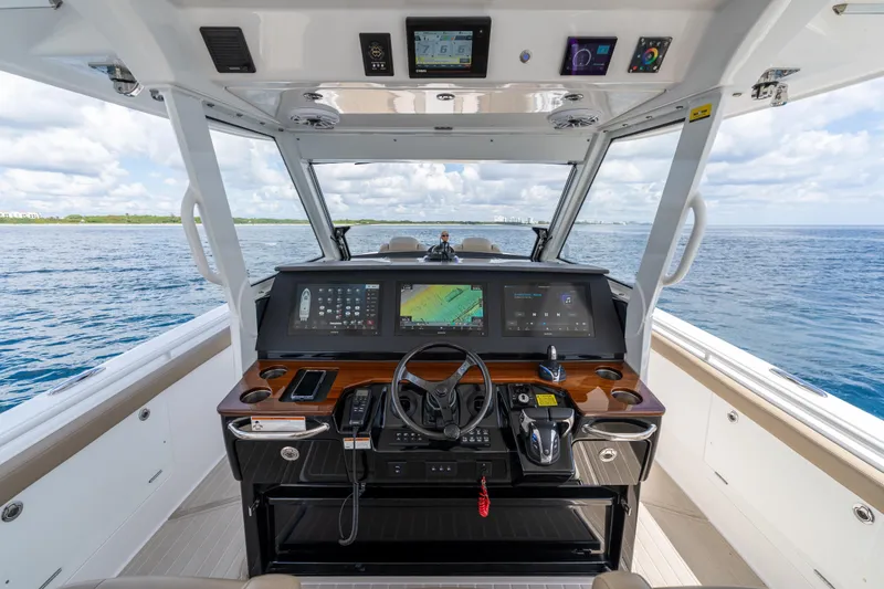 Slide: The Image of 2021 Everglades 395 Center Console helm with advanced navigation displays on open water. - 17