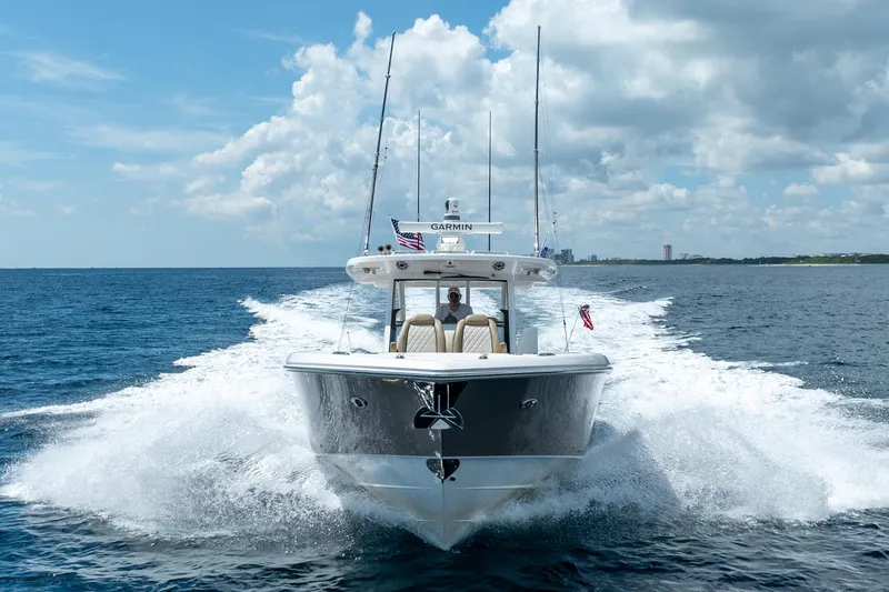 Slide: The Image of 2021 Everglades 395 Center Console boat cruising on open water under a cloudy sky. - 2