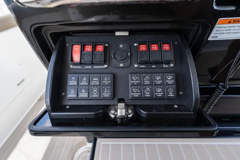 Slide: The Image of Control panel of 2021 Everglades 395 Center Console boat with various switches and buttons. - 24